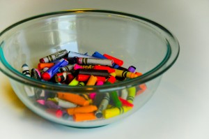 Clear Pyrex bowl of crayon pieces with wrappers